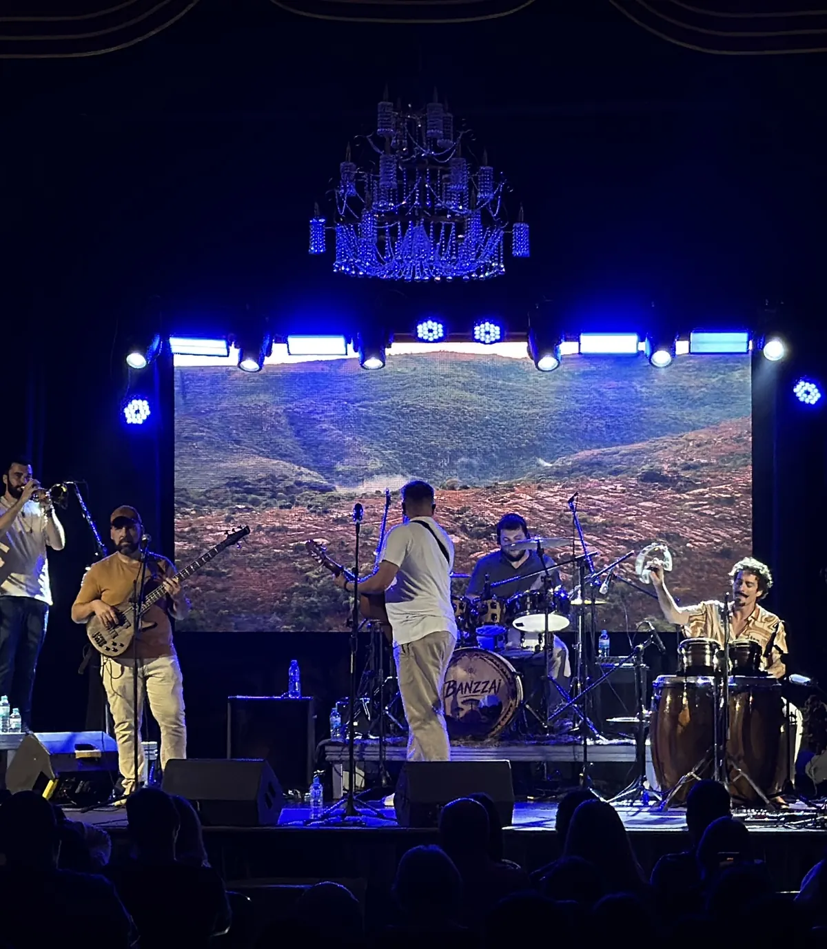 Banzzai no palco, com uma paisagem de terra vermelha projetada no telão ao fundo