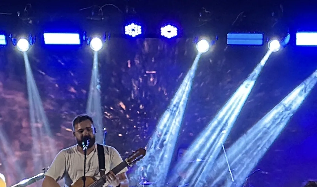 Vocalista com violão sob feixes de luz azul